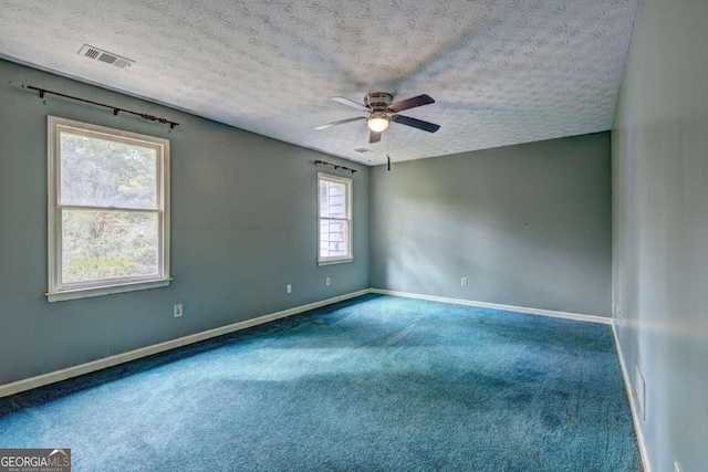 empty room featuring carpet, a textured ceiling, plenty of natural light, and ceiling fan