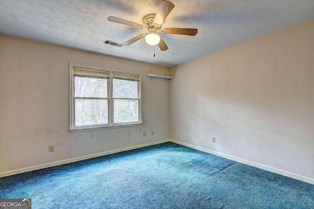 carpeted spare room featuring ceiling fan and a textured ceiling