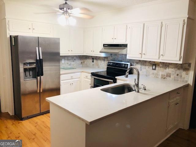 kitchen featuring black / electric stove, kitchen peninsula, white cabinets, and stainless steel refrigerator with ice dispenser