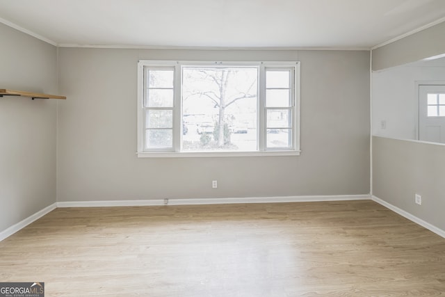 unfurnished room with light hardwood / wood-style flooring, a wealth of natural light, and ornamental molding