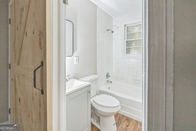 full bathroom with hardwood / wood-style flooring, vanity, toilet, and tiled shower / bath