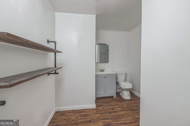 bathroom with hardwood / wood-style flooring, vanity, toilet, and ornamental molding