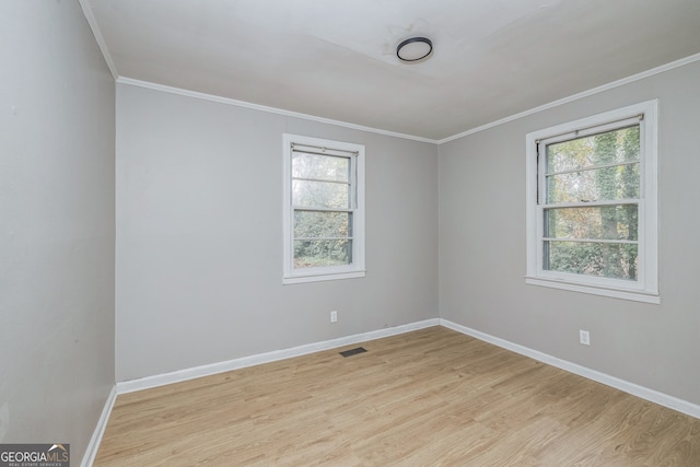unfurnished room featuring a healthy amount of sunlight, crown molding, and light hardwood / wood-style flooring
