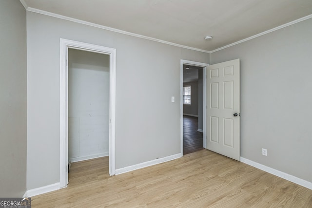 unfurnished bedroom with crown molding and light wood-type flooring