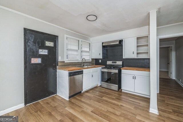 kitchen with wooden counters, sink, light hardwood / wood-style flooring, appliances with stainless steel finishes, and white cabinetry