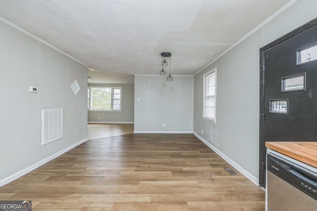 unfurnished dining area featuring light hardwood / wood-style floors and crown molding