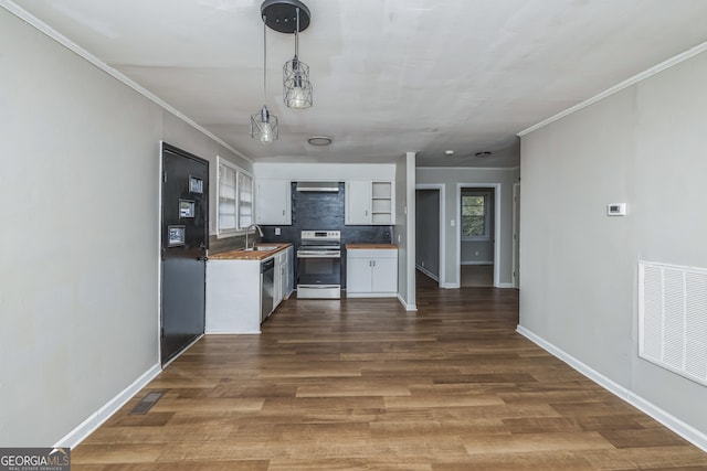 kitchen featuring backsplash, white cabinets, appliances with stainless steel finishes, decorative light fixtures, and dark hardwood / wood-style flooring