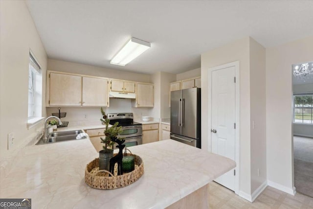 kitchen with sink, kitchen peninsula, stainless steel appliances, and light brown cabinetry