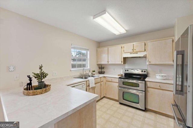 kitchen with light brown cabinetry, kitchen peninsula, sink, and appliances with stainless steel finishes