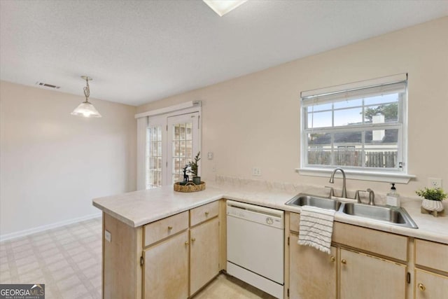 kitchen with dishwasher, sink, light brown cabinetry, decorative light fixtures, and kitchen peninsula