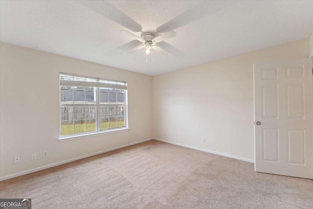 carpeted spare room with ceiling fan and a textured ceiling