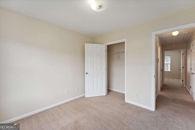 unfurnished bedroom with light colored carpet and a closet