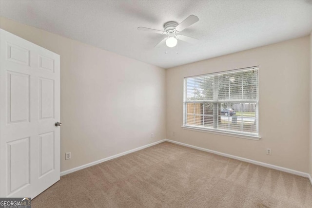 spare room with carpet and ceiling fan