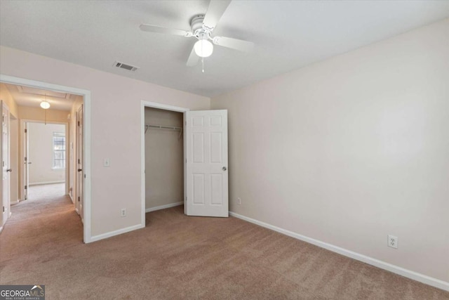 unfurnished bedroom featuring a closet, ceiling fan, and light colored carpet