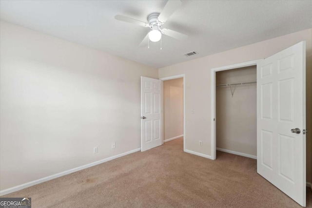 unfurnished bedroom featuring ceiling fan, a closet, and light carpet