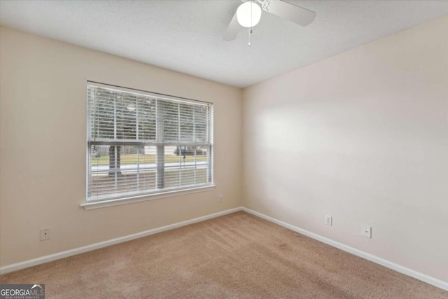 carpeted empty room featuring ceiling fan