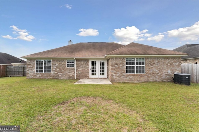 rear view of house featuring french doors, a yard, a patio, and central AC unit