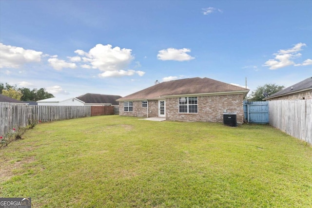 rear view of house with a yard and central AC unit