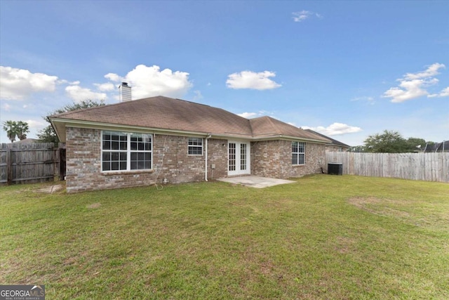 back of house with a lawn and french doors