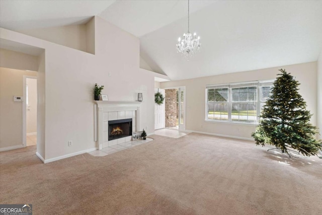 unfurnished living room with a fireplace, light colored carpet, high vaulted ceiling, and a chandelier