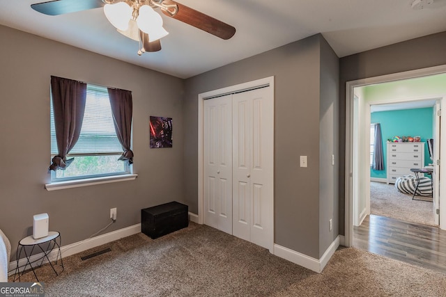 unfurnished bedroom featuring carpet flooring, ceiling fan, and a closet