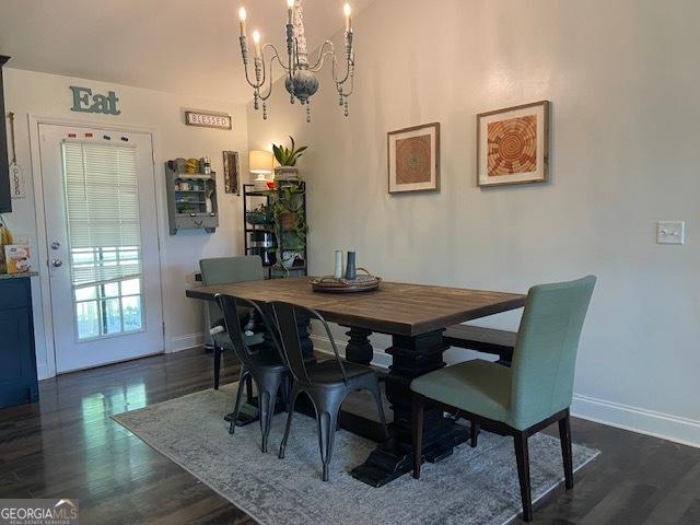 dining space featuring a notable chandelier and dark hardwood / wood-style flooring