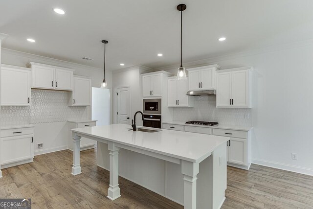 2198 Old Swimming Pool Rd, Jefferson, GA 30549 - kitchen with gas cooktop, a sink, stainless steel microwave, backsplash, and under cabinet range hood