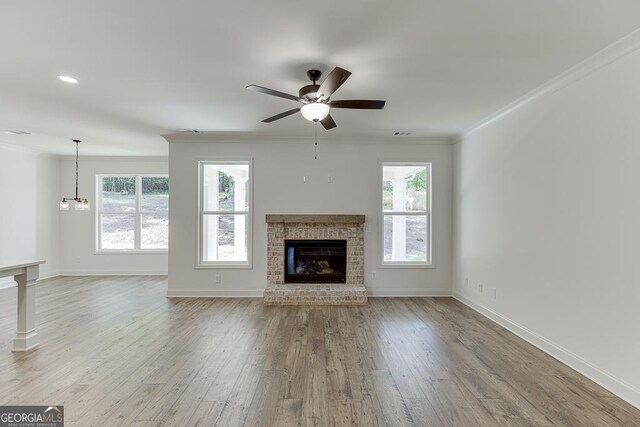 2198 Old Swimming Pool Rd, Jefferson, GA 30549 - unfurnished living room with wood finished floors, ornamental molding, baseboards, a fireplace, and ceiling fan with notable chandelier
