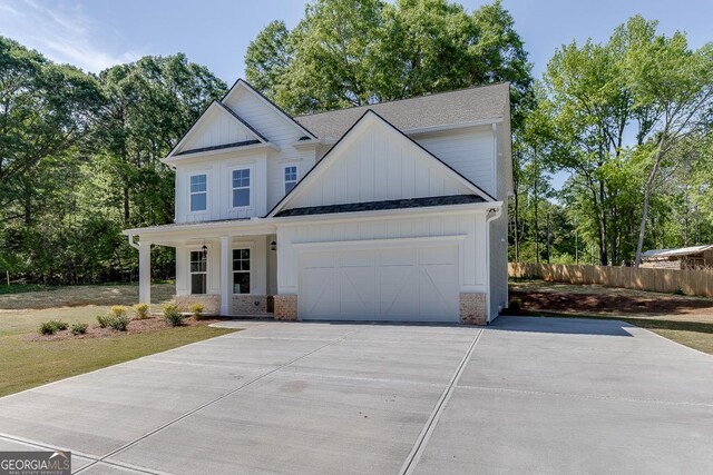 2198 Old Swimming Pool Rd, Jefferson, GA 30549 - modern inspired farmhouse featuring concrete driveway, board and batten siding, an attached garage, fence, and roof with shingles