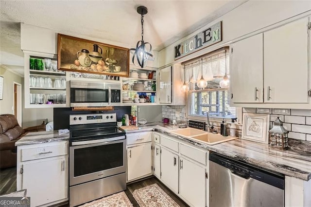 kitchen featuring white cabinets, sink, hanging light fixtures, decorative backsplash, and stainless steel appliances