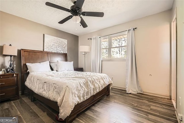 bedroom with a textured ceiling, ceiling fan, and dark wood-type flooring