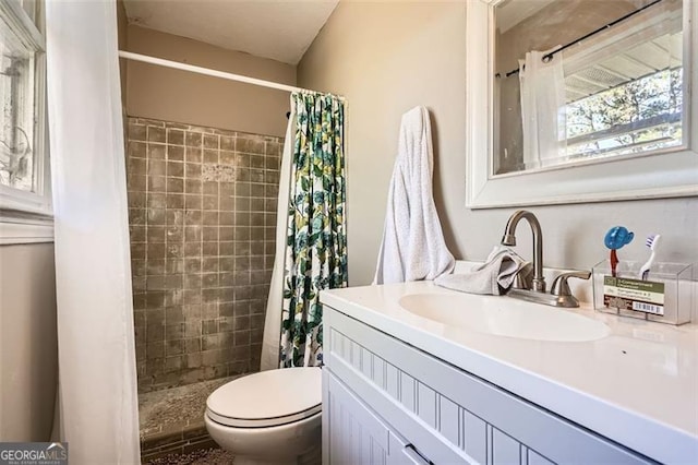 bathroom with a shower with shower curtain, vanity, and toilet