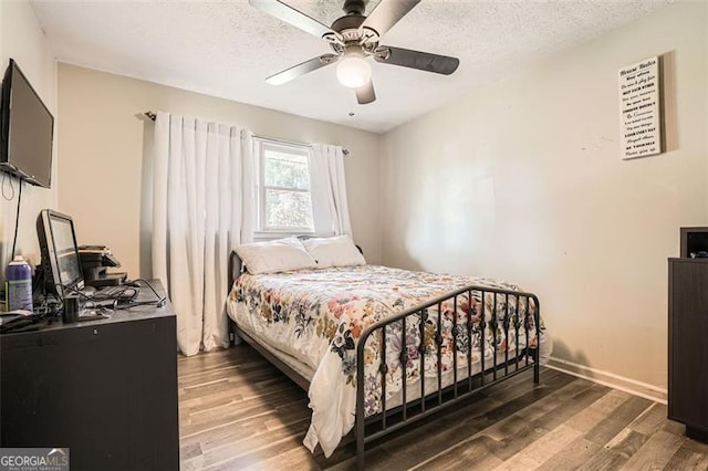 bedroom featuring ceiling fan, dark wood-type flooring, and a textured ceiling