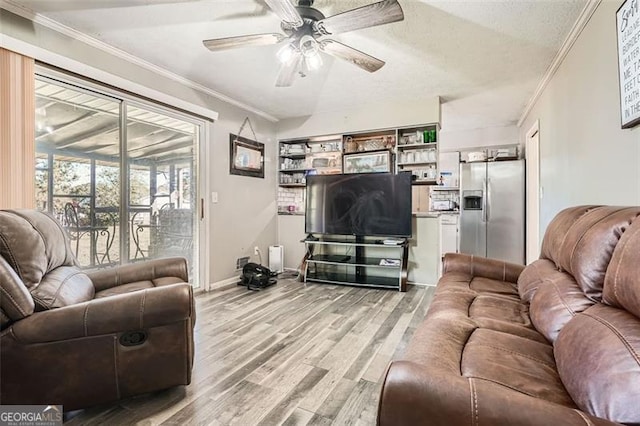 living room featuring a textured ceiling, light wood-type flooring, ceiling fan, and ornamental molding