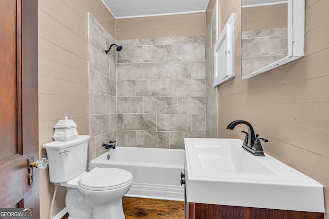 bathroom featuring hardwood / wood-style floors, toilet, wood walls, and tiled shower / bath combo