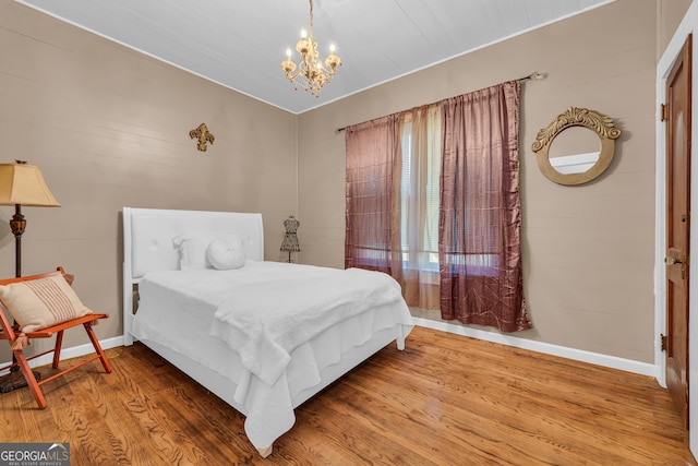 bedroom featuring wood-type flooring and a chandelier