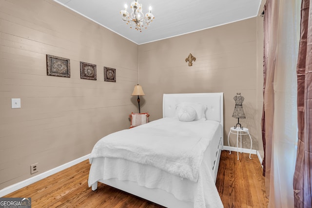 bedroom with hardwood / wood-style flooring and a notable chandelier