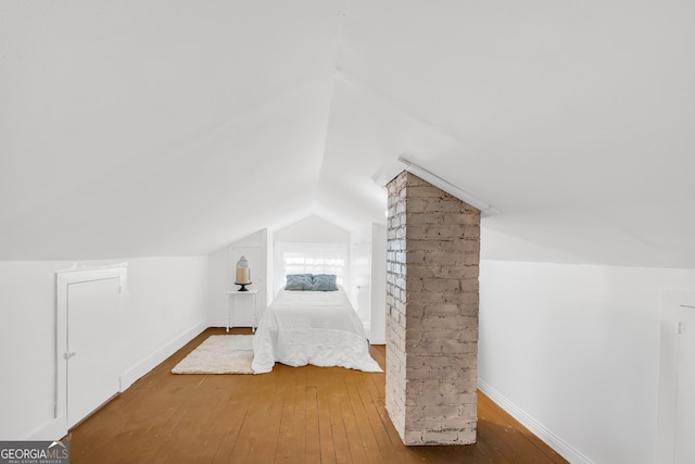 unfurnished bedroom featuring wood-type flooring and lofted ceiling