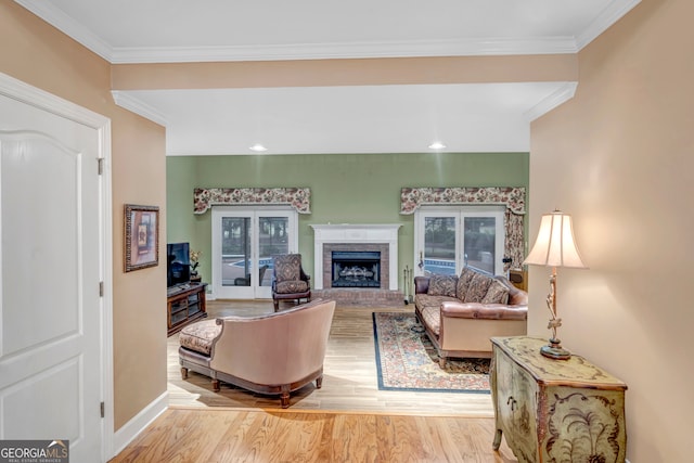 living room featuring a fireplace, light wood-type flooring, and crown molding