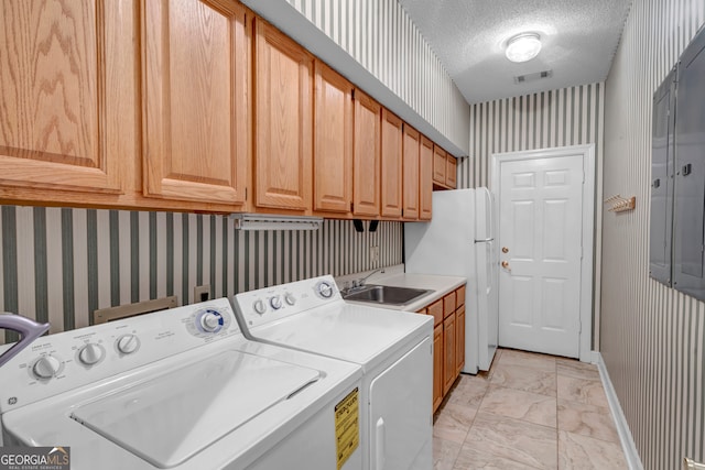 washroom featuring cabinets, independent washer and dryer, a textured ceiling, and sink