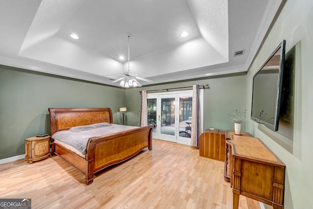 bedroom featuring access to outside, a raised ceiling, ceiling fan, and light hardwood / wood-style floors