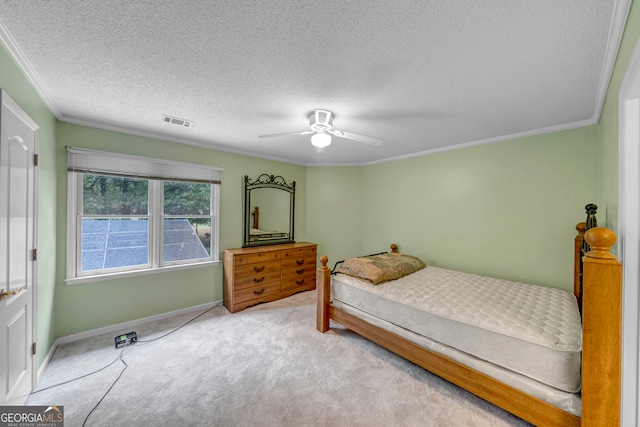 carpeted bedroom featuring ceiling fan, crown molding, and a textured ceiling