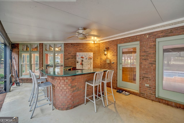 interior space featuring a kitchen breakfast bar, plenty of natural light, and brick wall