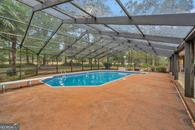 view of pool with glass enclosure and a patio