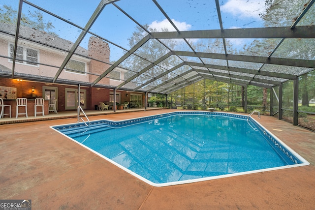 view of swimming pool with a patio and glass enclosure