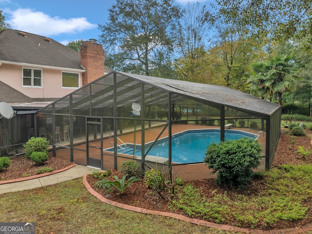 view of swimming pool featuring glass enclosure