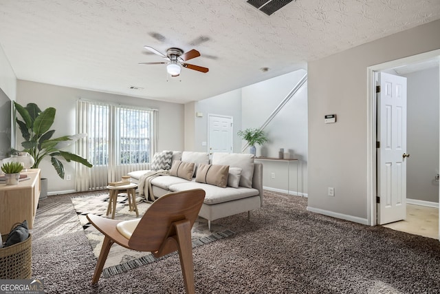 carpeted living room featuring a textured ceiling and ceiling fan