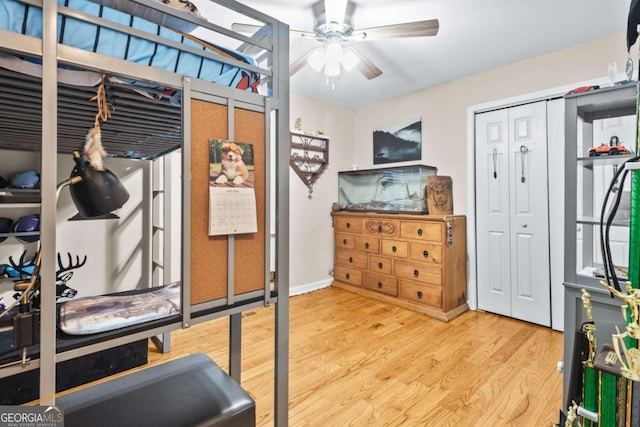 exercise room with ceiling fan and light hardwood / wood-style flooring