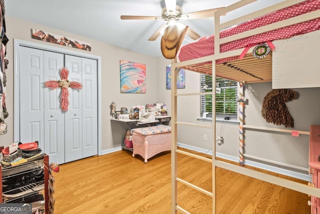 bedroom featuring hardwood / wood-style flooring, ceiling fan, and a closet