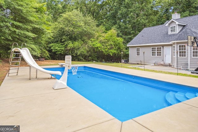 view of pool featuring a water slide and a patio